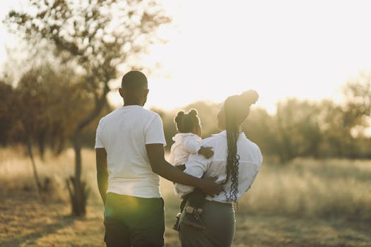 A family enjoys a peaceful walk in a sunlit park during fall, embodying warmth and togetherness.
