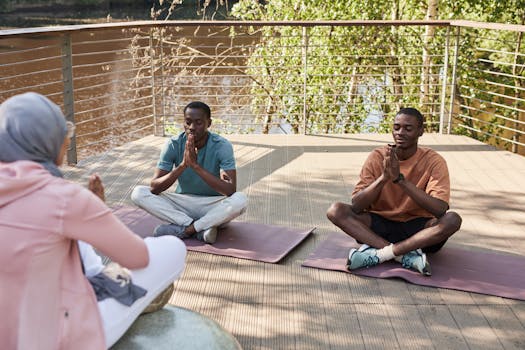 Two men and a woman engage in outdoor yoga practice by a serene river.